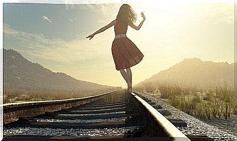 woman walking on railway tracks