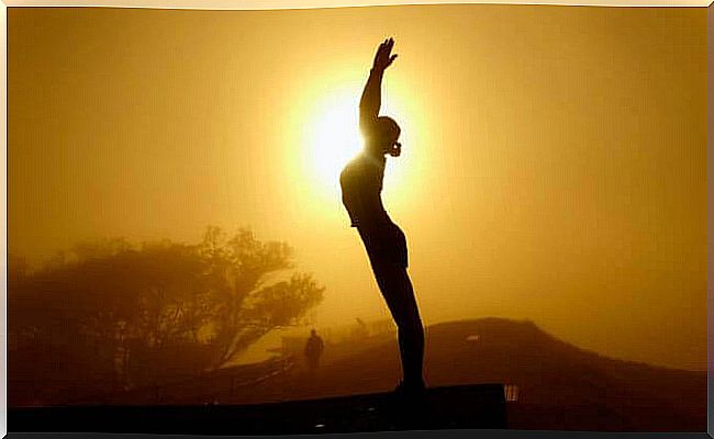 woman doing tai chi at sunset