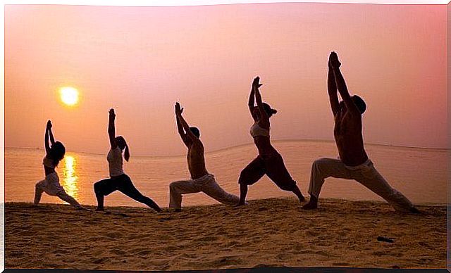 a group of people practice taiji on the beach