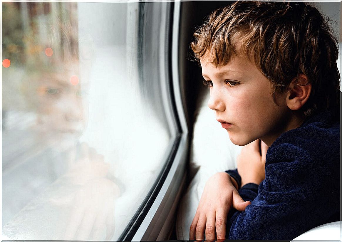 A sad child looks out the window and thinks about the family’s beliefs