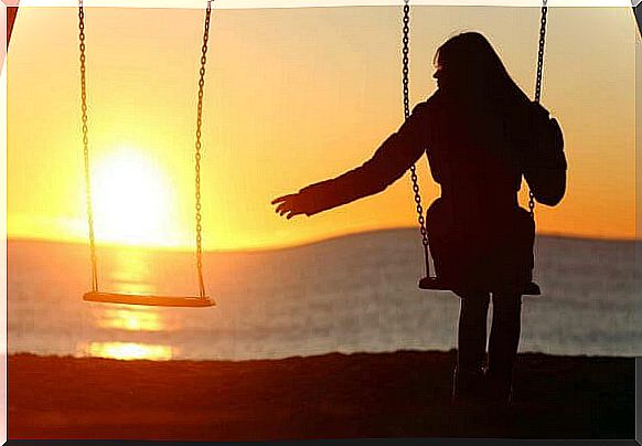 A woman swings alone at sunset