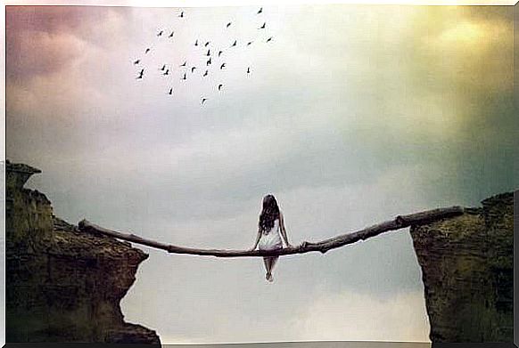 A woman is sitting on a wooden bridge